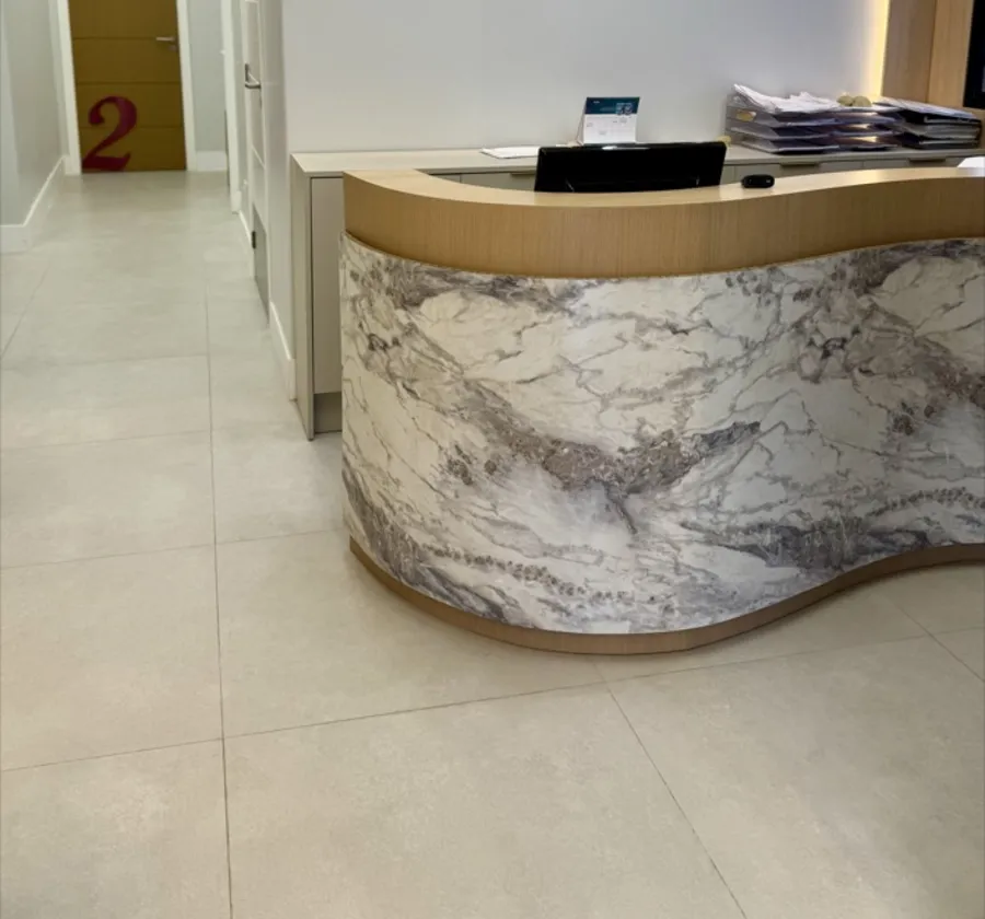 Recepção da clínica, com balcão elegante e ambiente claro